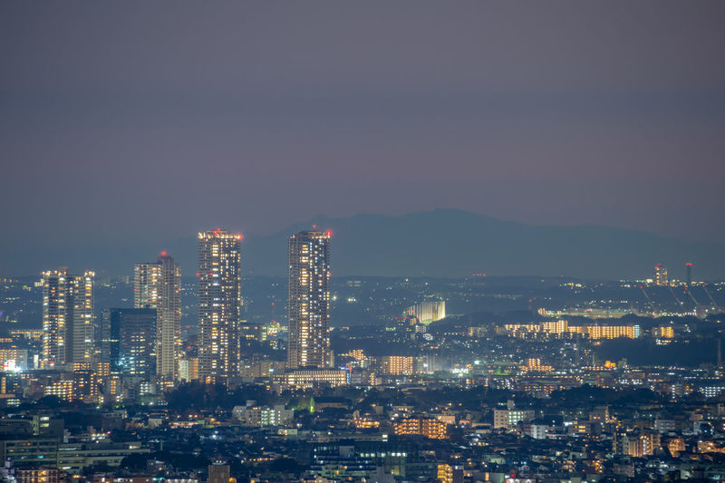 Illuminated cityscape against clear sky at night