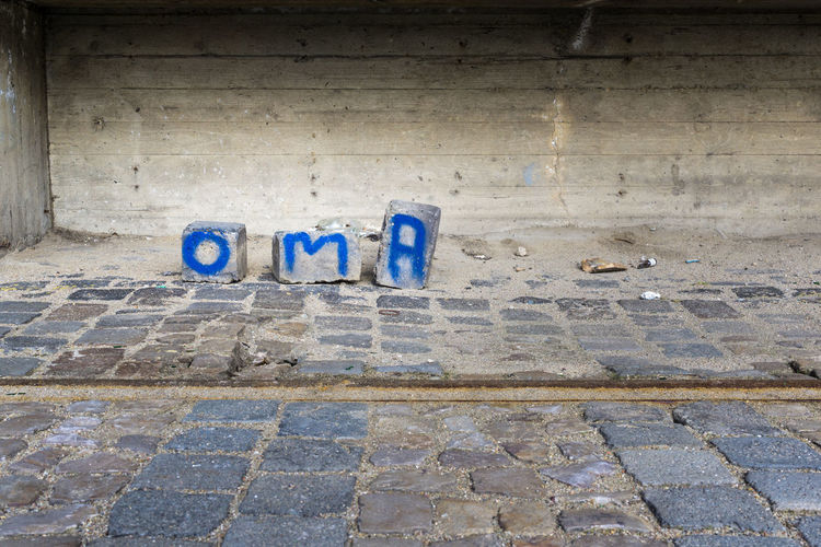 Concrete blocks with blue paint text against wall