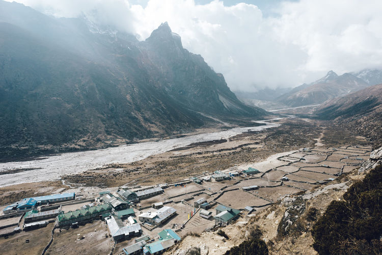 High angle view of houses amidst mountains during foggy weather