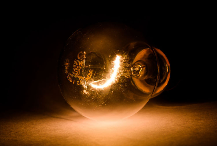 Close-up of illuminated crystal ball against black background