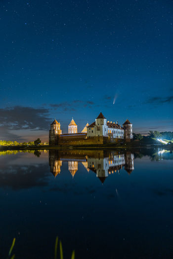 Comet neowise in a night landscape. mir castle in belarus.