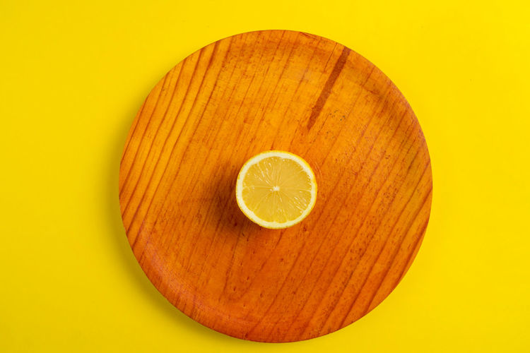 Directly above shot of empty plate on yellow background