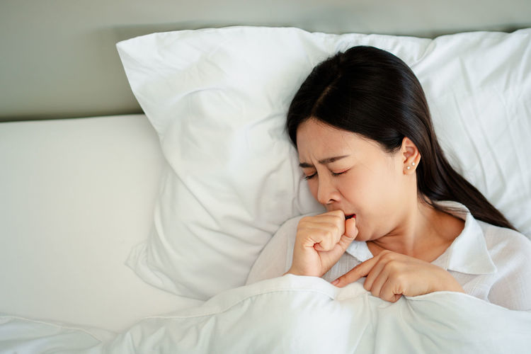 Midsection of woman sleeping on bed