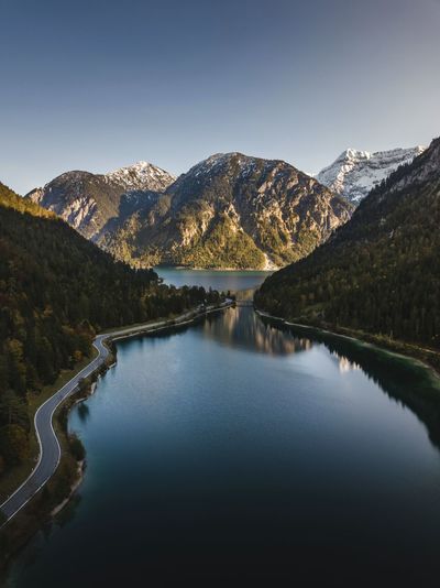 Scenic view of lake and mountains against clear sky drone