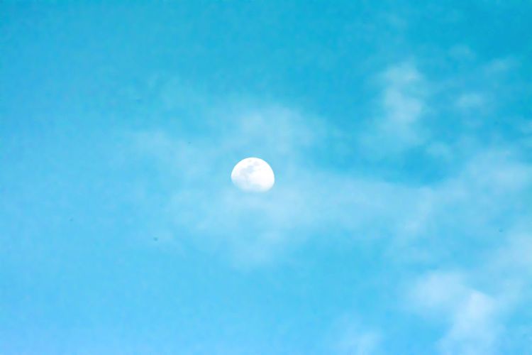 Low angle view of moon against blue sky