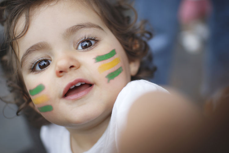 Close-up of cute baby girl with face paint