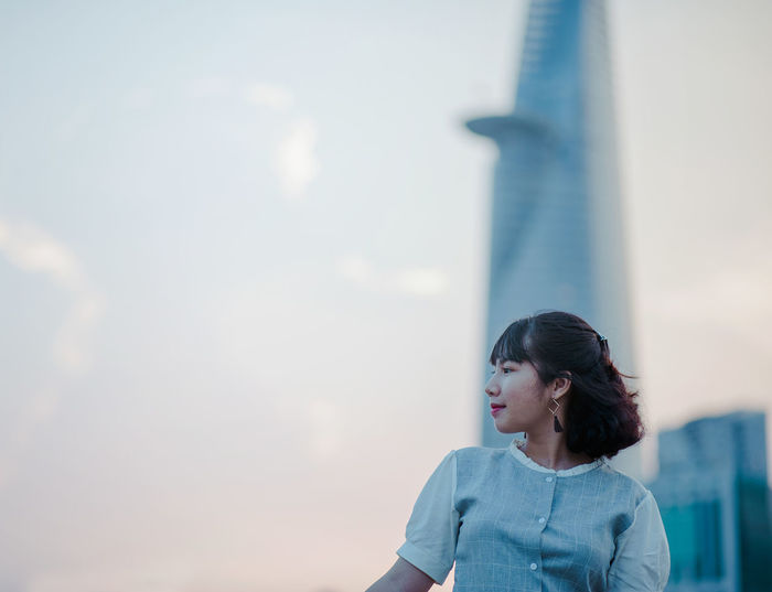Young woman against tower in city