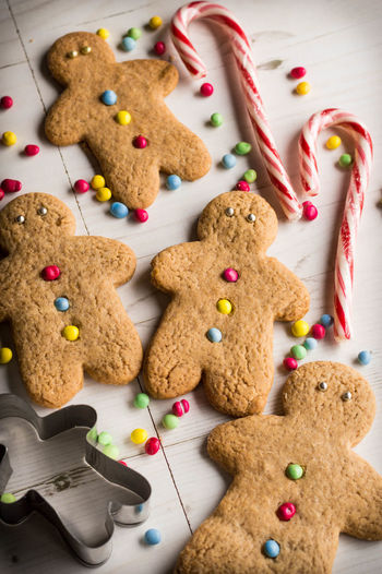 Close-up of gingerbread cookies with cutter and candy cane on table