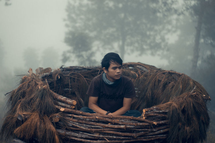 Young man sitting in haystack