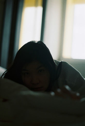 Portrait of girl lying on bed at home