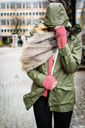 Portrait of woman walking protecting herself from wind