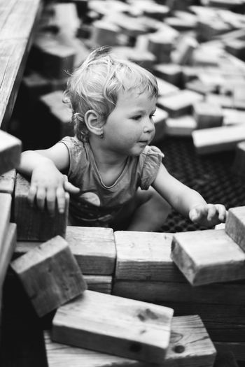 High angle view of cute baby girl sitting amidst wood