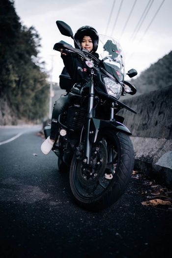 Portrait of girl riding motorcycle on road