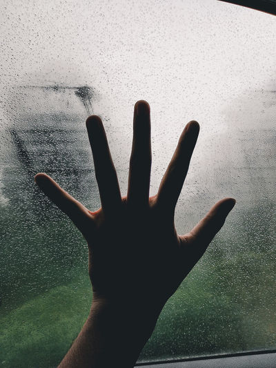 Close-up of hand on glass window