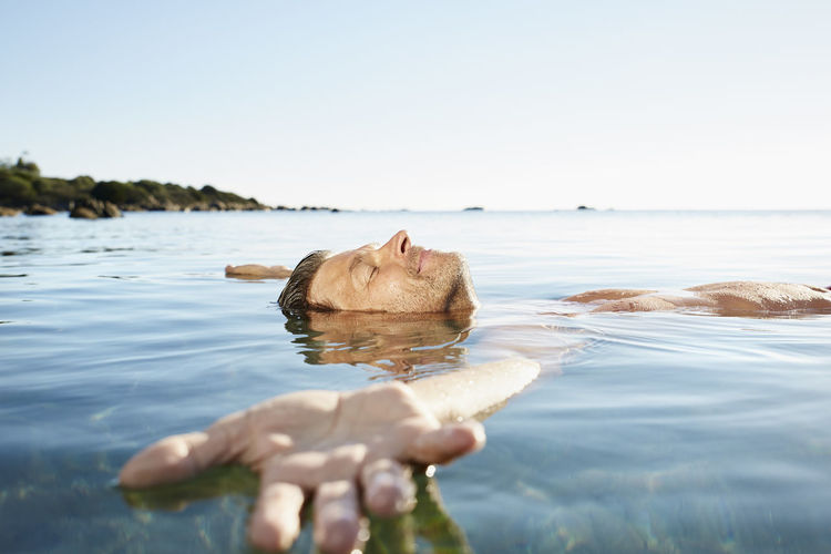 Relaxed mature man floating in the sea