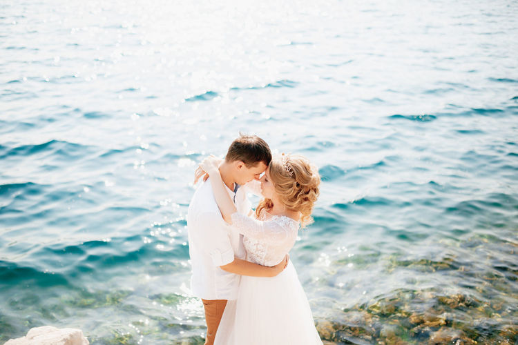 High angle view of couple embracing by sea
