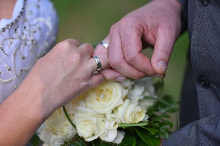 Midsection of wedding couple wearing rings