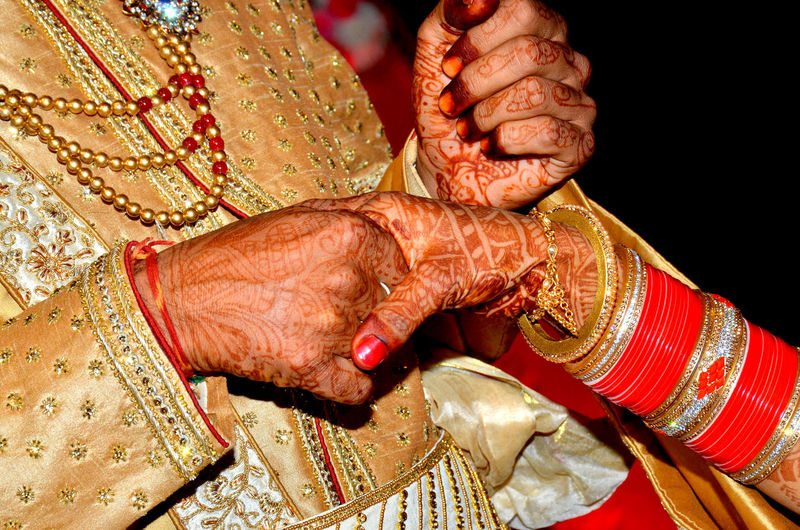 Midsection of bridegroom holding bride hand