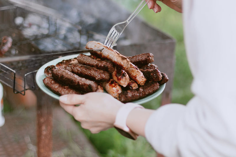 Female hands holding plate with hot bbq 