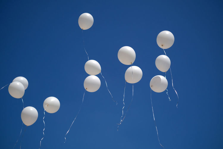 Low angle view of balloons against blue sky