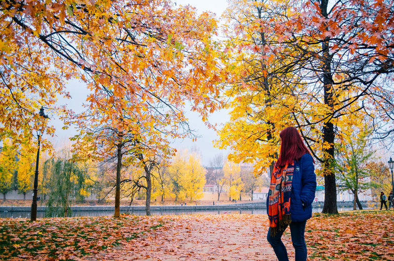 Woman standing by trees during autumn
