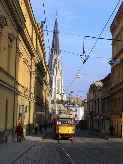 Tramway amidst buildings in city against sky
