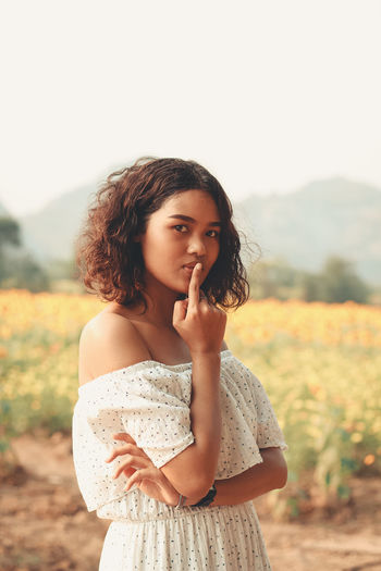 Portrait of young woman standing on field