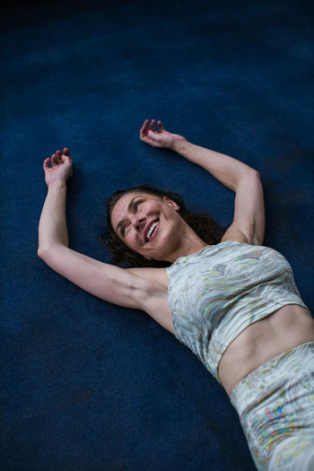 Woman smiling while laying down on floor