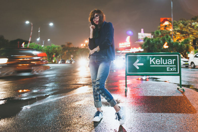 Man standing on road at night