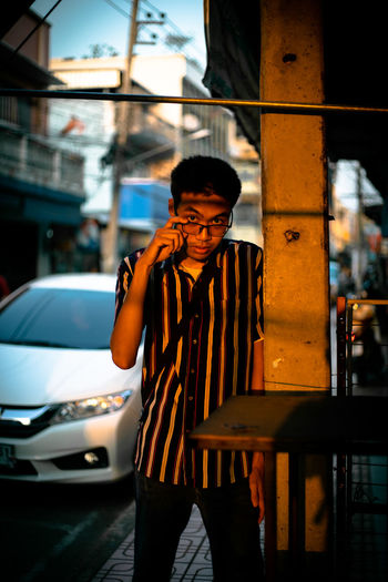 Portrait of young man wearing eyeglasses standing on street
