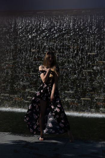 Portrait of woman standing against water