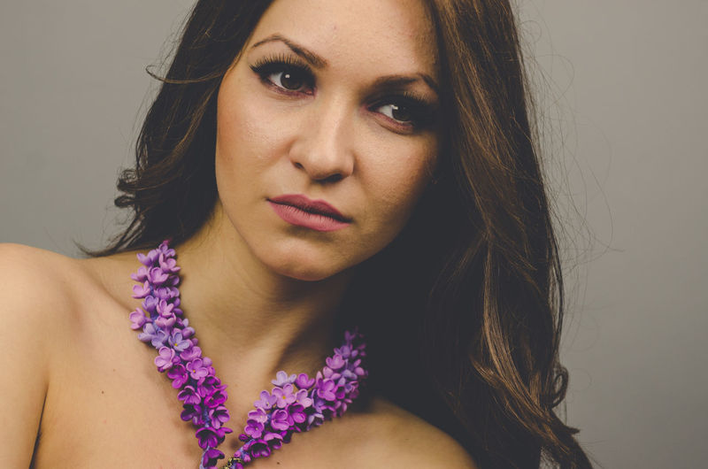 Close-up portrait of a beautiful young woman over purple background