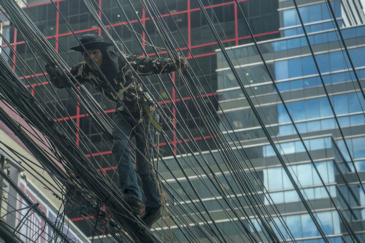 Low angle view of man on glass building