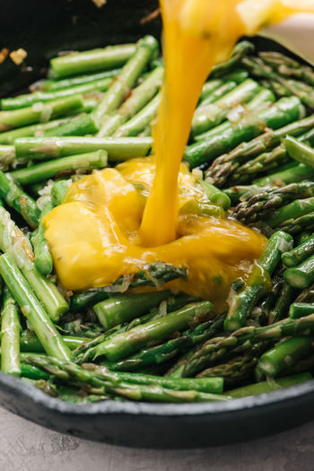 Adding eggs to skillet for asparagus frittata
