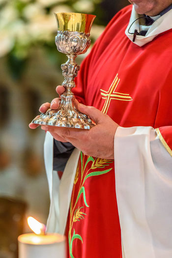 Midsection of priest holding container in church
