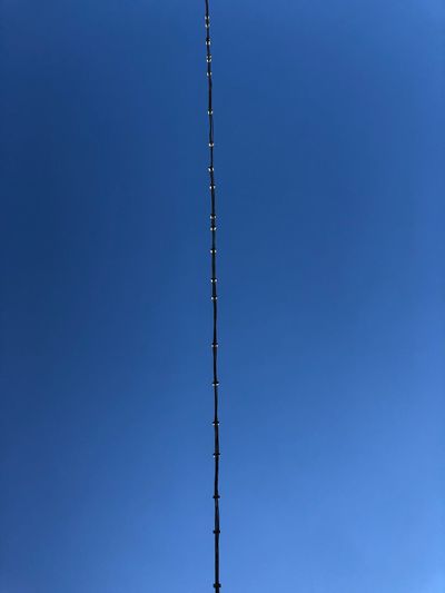 Low angle view of a cable against clear blue sky