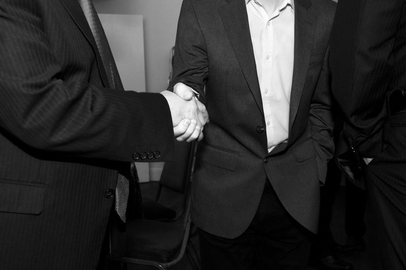 Midsection of businessmen shaking hands