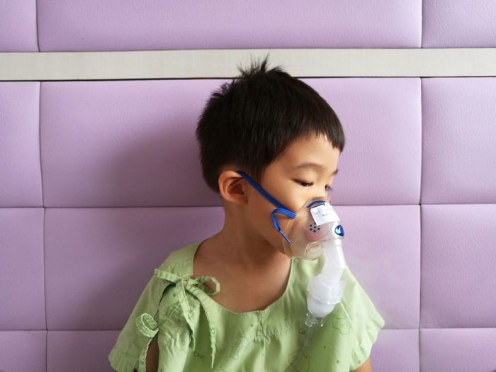 Close-up of cute boy wearing oxygen mask