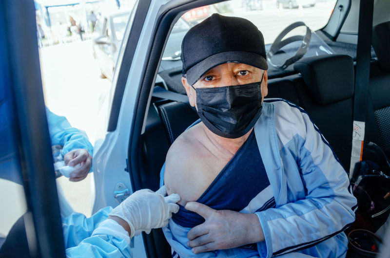 Portrait of man taking vaccination in car