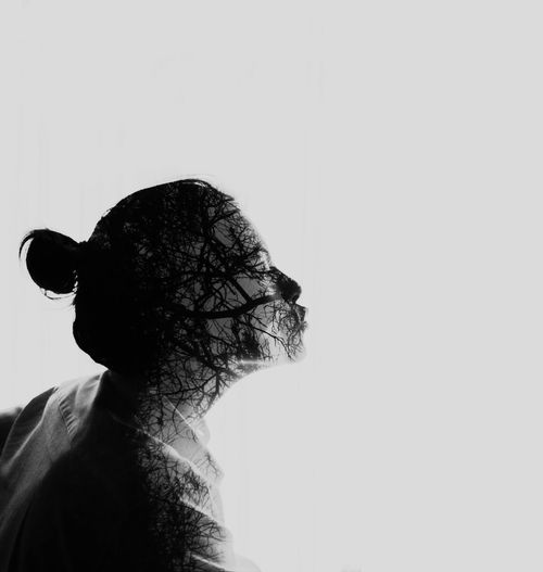 Double exposure image of girl with trees against gray background