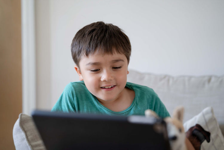 Portrait of boy using digital tablet at home