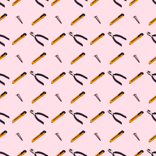 Pliers, self-tapping screws and knives on a pink background, pattern, hard shadow
