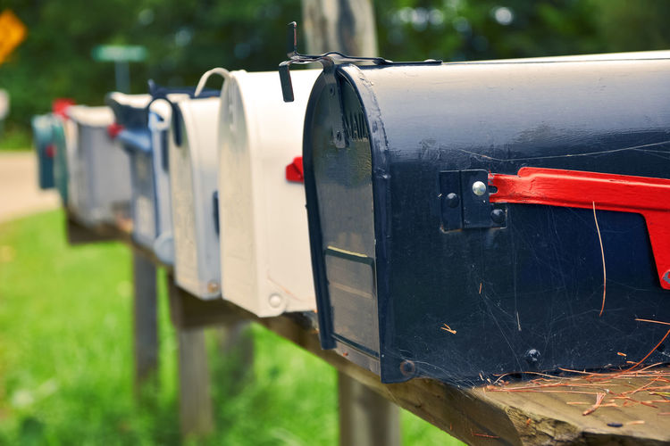 An isolated row of metal us mail boxes on wooden post in the countryside mail concept. new york
