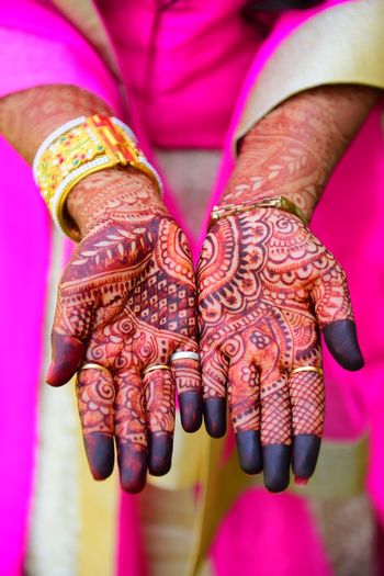 Midsection of woman showing henna tattoo on her hands