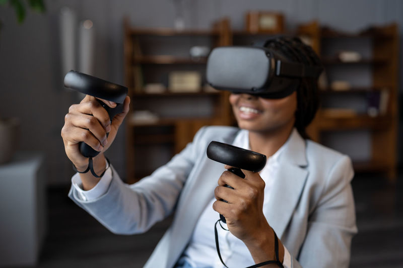 Joyful african businesswoman vr headset playing immersive realistic game in virtual reality