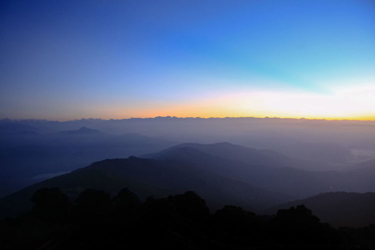Scenic view of silhouette mountains against sky during sunrise