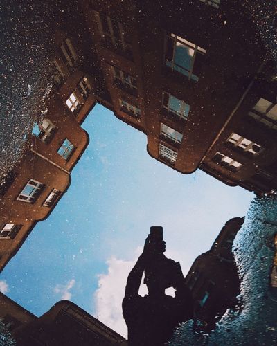 Reflection of person on puddle in city