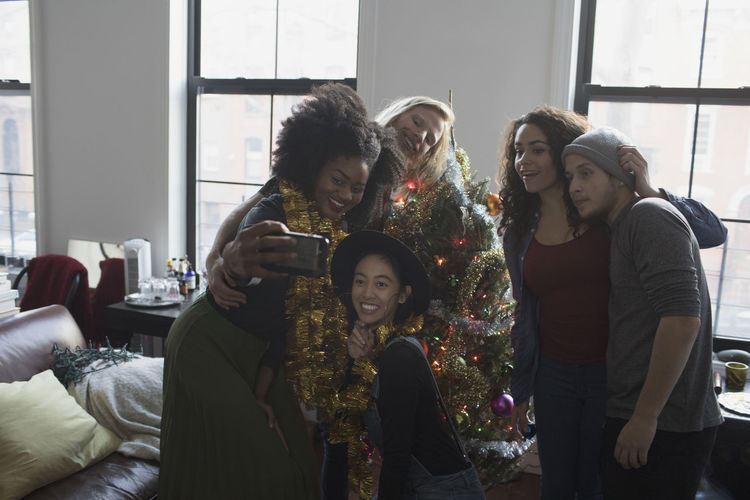 A group of people taking a photo with a christmas tree