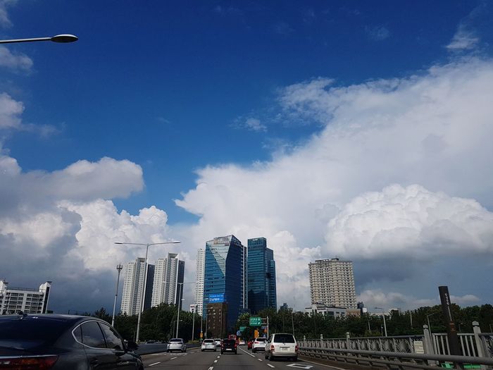 View of cityscape against cloudy sky