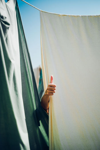 Cropped hand of person gesturing against textile